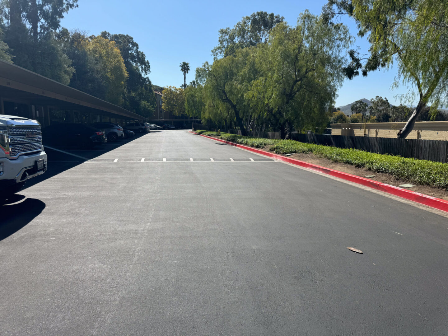 Image of a black color road with some trees